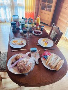 a wooden table with plates of breakfast food on it at Tantra klub - private room in a shared wooden house in Prague