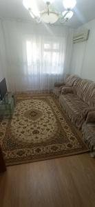 ein Wohnzimmer mit einem Sofa und einem Teppich in der Unterkunft 3 комнатная квартира на Курмангазы - 3 room apartment on Kurmangazy in Atyrau