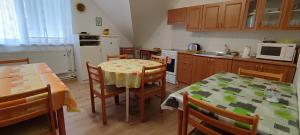 eine Küche mit einem Tisch und Stühlen sowie eine Küche mit einem Tisch und einem Stuhl in der Unterkunft Penzión Veperec in Hokovce