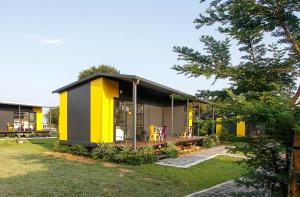 a yellow and grey house with a yard at SleepOver Phabeni in Hazyview