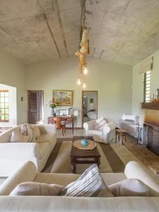a living room with white furniture and a ceiling at Green Cottage Chamarel in Chamarel