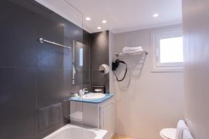 a bathroom with a shower and a sink and a toilet at Hôtel Vendôme in Nice
