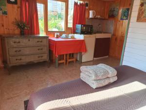 1 dormitorio con mesa y cocina de color rojo en "Suite Dreams" Descanso Cerca del Mar, en El Quisco