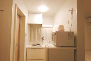 a kitchen with a microwave on top of a counter at 東京昭島迎賓館 in Akishima