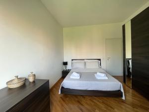 a bedroom with a bed with white sheets and wooden floors at Davide Rome Apartment in Rome