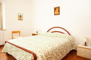 a bed in a white room with a bedspread on it at LE PIUME B&B in Cupramontana