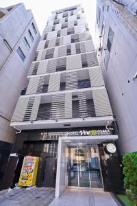 大阪市にあるホテルVINE大阪北浜のホテルの入り口が正面にある大きな建物