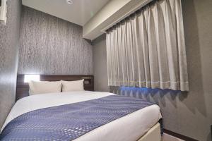 a bedroom with a large bed and a window at HOTEL VINE OSAKA KITAHAMA in Osaka