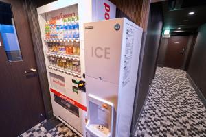 a refrigerator filled with drinks in a hallway at HOTEL VINE OSAKA KITAHAMA in Osaka