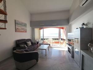 a living room with a couch and a table at Etoile d'Azur in Sainte-Maxime