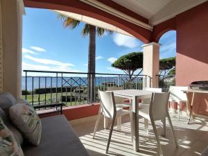 a patio with a table and chairs on a balcony at Etoile d'Azur in Sainte-Maxime