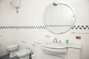 a white bathroom with a sink and a mirror at LE PIUME B&B in Cupramontana