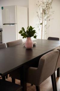 a dining room table with a vase with a plant on it at Enjoy a renovated retreat with outdoor bath in Creswick