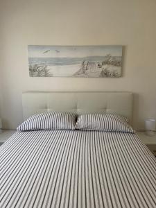 - un lit avec une couette rayée dans une chambre dans l'établissement Casa Fiorella - Vista Mare, à Palau