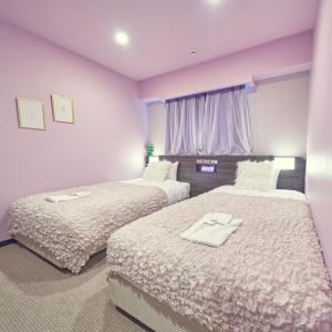 two beds in a hotel room with pink walls at HOTEL VINE OSAKA KITAHAMA in Osaka +37 photos