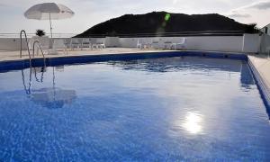 a large blue swimming pool with chairs and an umbrella at APARTAMENTO TURÍSTICO CARBONERAS in Carboneras