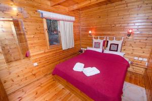 1 dormitorio con 1 cama en una cabaña de madera en משק חפר - בקתות כפריות עם פרטיות מלאה - כולל שעה של טיול רנג'ר זוגי עצמאי, en Abirim
