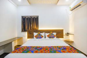 1 dormitorio con 1 cama con colcha colorida en FabHotel W Grand Suites, en Hyderabad