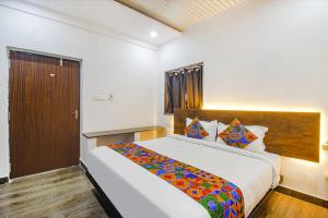 a bedroom with a large bed in a room at FabHotel W Grand Suites in Hyderabad