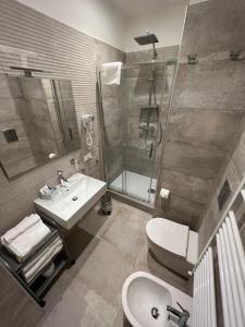 a bathroom with a sink and a shower and a toilet at Maqueda Suites in Palermo