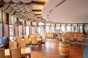 a restaurant with wooden tables and chairs and windows at Amenity Hotel & Resort Lipno in Lipno nad Vltavou