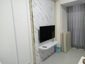 a bathroom with a sink and a tv on a wall at 1 Bed Apartment Pollux for Rent in Nagoya +3 photos