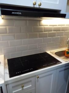 a black stove top oven in a kitchen at 1 Bed Apartment Pollux for Rent in Nagoya