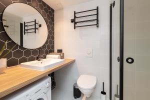 a bathroom with a sink and a toilet and a mirror at Hilltop Apartments - Ilmarine district in Tallinn