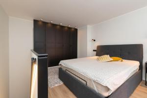 a bedroom with a large bed with a black headboard at Hilltop Apartments - Ilmarine district in Tallinn
