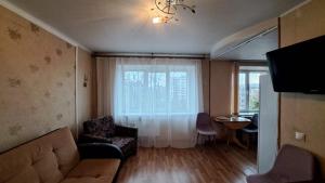 sala de estar con sofá, mesa y ventana en Sporta 2, en Daugavpils