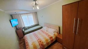 a bedroom with a bed and a dresser and a window at Sporta 2 in Daugavpils