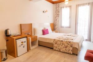a bedroom with a bed and a tv in a room at MANDALİN AKYAKA in Akyaka