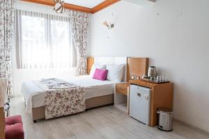 a bedroom with a bed with a pink pillow at MANDALİN AKYAKA in Akyaka