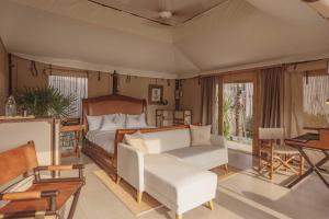 普吉镇Aladdin Luxury Camp Phuket的一间卧室，里面有一张床、一张沙发和一张桌子