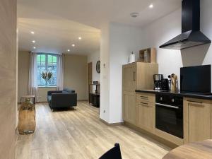 a kitchen and living room with a stove top oven at Gite du Pavillon in Rocroi