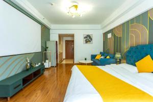 a bedroom with a large bed and a couch at Dalian Hong Xi Yuan Apartment Wanda Plaza in Dalian