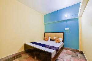 um quarto com uma cama com uma parede azul em SPOT ON Luv-kush Inn em Bankipur