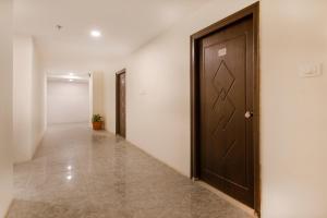 um corredor com uma porta castanha num edifício em Capital O 10225 Wild Wings Hotel Near Omni Hospital Lane Nagole main road em Upal