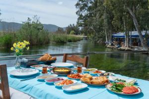 a table with food on it next to a river at MANDALİN AKYAKA in Akyaka