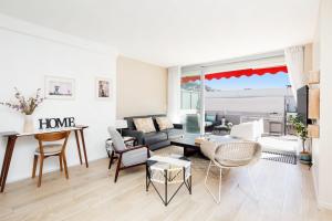 ein Wohnzimmer mit einem Sofa und einem Tisch in der Unterkunft XXL 2 beds with XXL terrace next to Martinez Hotel in Cannes
