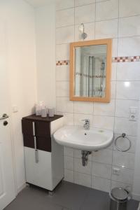 ein Bad mit einem Waschbecken und einem Spiegel in der Unterkunft Altes Weingut an der Vogtei in Senheim