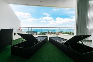 ein Balkon mit Stühlen und Blick auf das Meer in der Unterkunft Large Penthouse 3BR with jacuzzi, Best for Kids in Ka Rorn