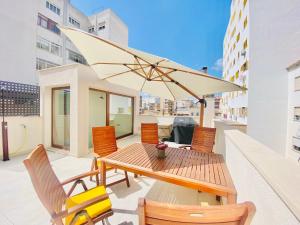 a table and chairs with an umbrella on a balcony at Hotel-Apartment with big terrace in Palma de Mallorca