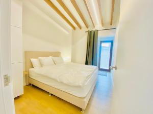1 dormitorio con cama blanca y puerta en Hotel-Apartment with big terrace, en Palma de Mallorca