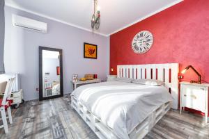 トスコラーノ・マデルノにあるVilla Giulia Rooms & Bikeの白いベッドと赤い壁が備わるベッドルーム1室が備わります。