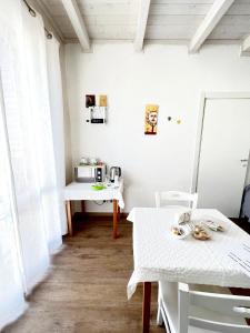 a white room with two tables and a microwave at Il Girasole in Ostuni