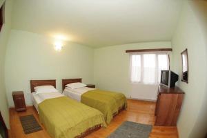 una camera da letto con due letti e una televisione di Casa dintre Vii a Jidvei Altre 20 foto