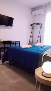 アグリジェントにあるCasa Villaggio Pirandelloの青い毛布が付いた部屋のベッド1台分です。