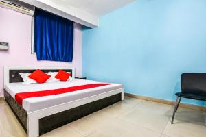 a bedroom with a bed with red pillows and a window at OYO Hotel River View in Patna