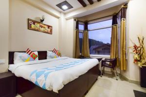 a bedroom with a bed and a large window at OYO Home Sam Villa Studio in Shimla